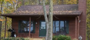 Exterior of a wooden cabin with a green door