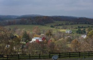 Rolling country hills and fall foliage with a split-rail fence