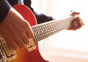 Close-up photo of a person playing a guitar