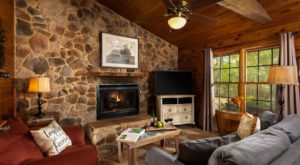 view of sitting room with stone wall, fireplace, and TV