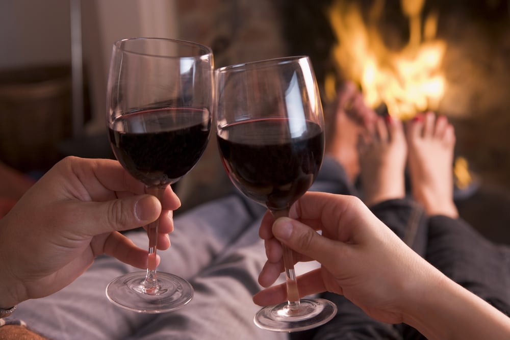 couple drinking red wine by the fire at our romantic shenandoah valley bed and breakfast