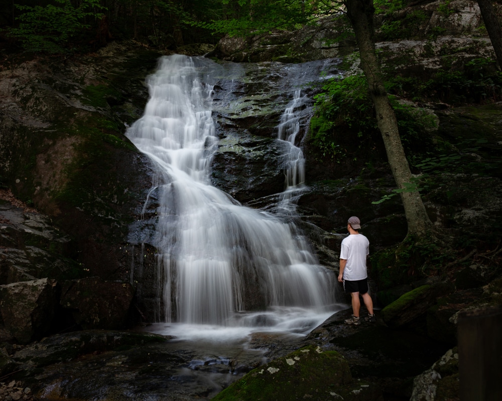 Man standing in front of the Crabtree Falls Trail - one of the best waterfalls in Virginia to visit after White Rock Falls