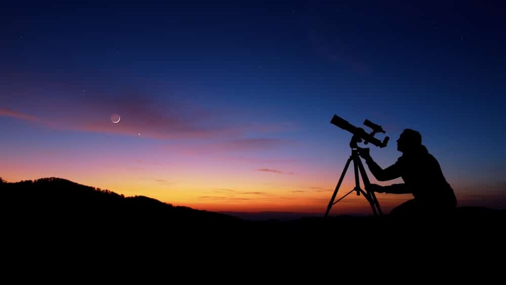 Man with a telescope enjoying stargazing at places like Natural Bridge State Park in Virginia