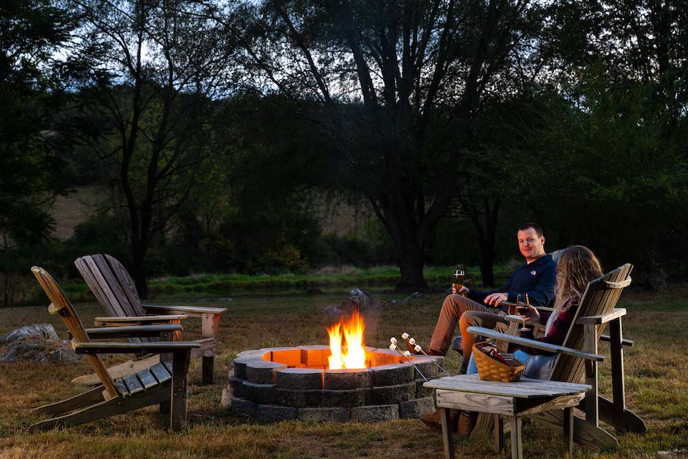 Couple sitting by the fire roasting s'mores during their couple's getaway in Virginia